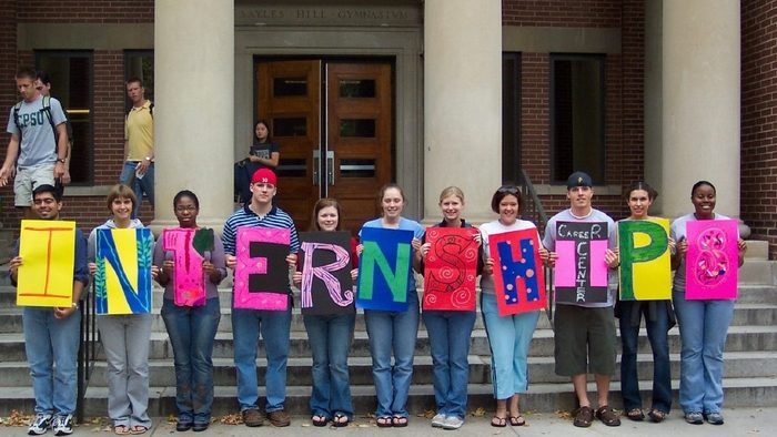 students holding letters that spell out "internships"